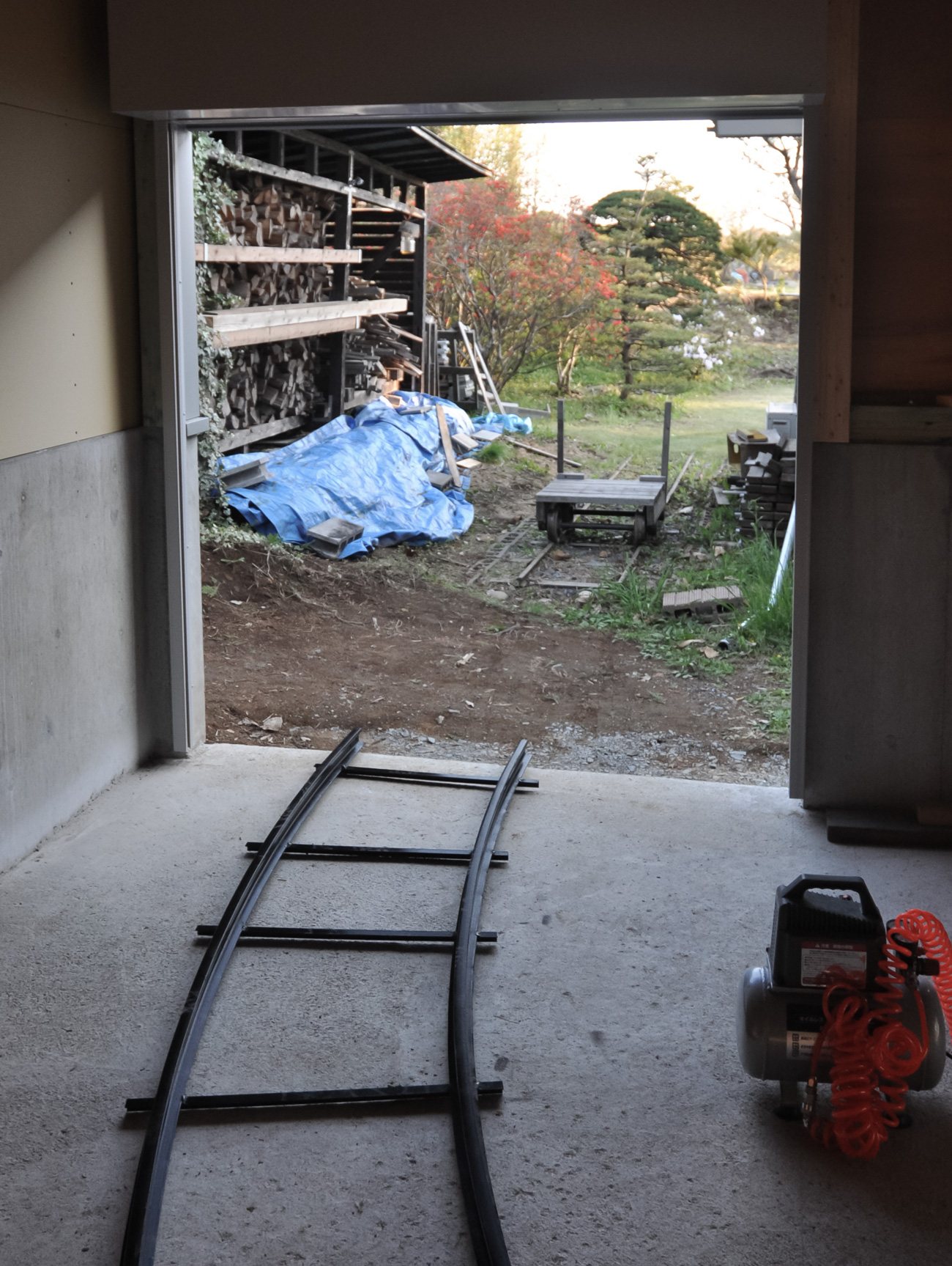 トロッコで敷地北側の薪棚から薪を搬入