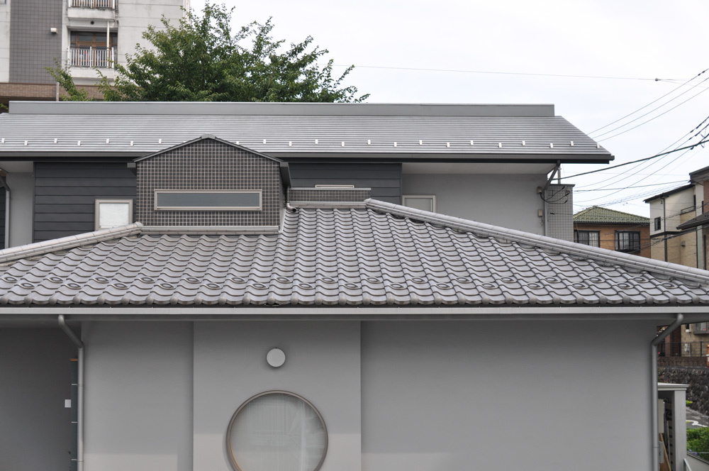 耐震を考えて、1階屋根は日本瓦、2階はガルバニウム鋼板（軽量材）の屋根材を使用