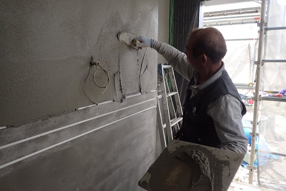 外壁のモルタル塗り（上塗り）の作業の様子