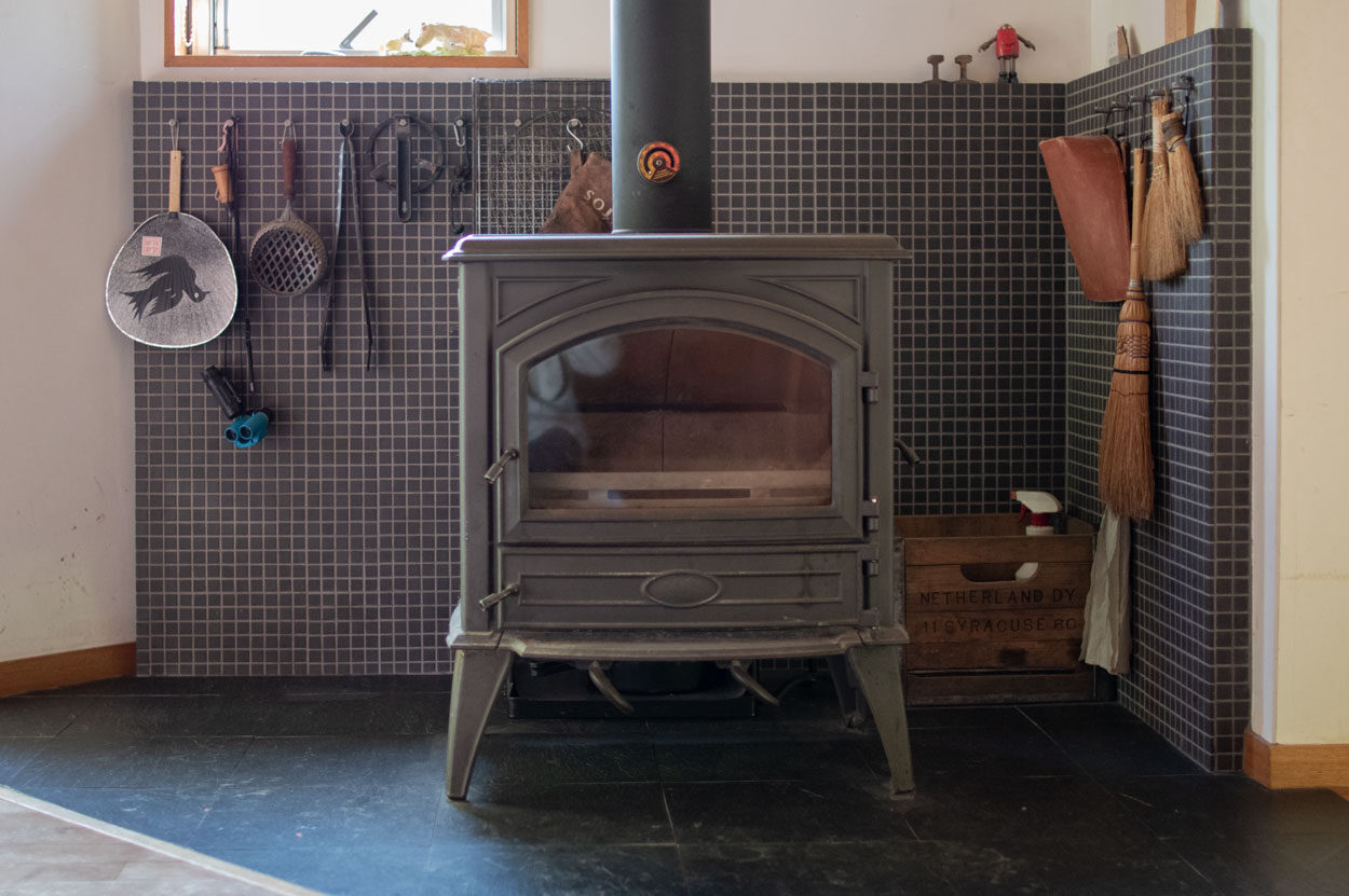 薪ストーブの周りは黒いモザイクタイルで仕上げてあります。床は300mmの玄昌石張り。
