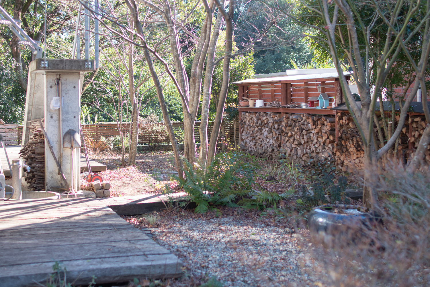 【我が家の冬の庭】 隣地との塀を兼用して薪棚が並んでいます